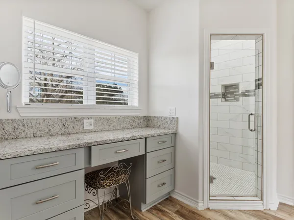 a bathroom with a granite countertop sink a mirror and a shower