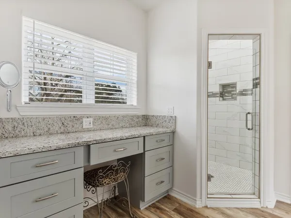 a bathroom with a granite countertop sink a mirror and a shower