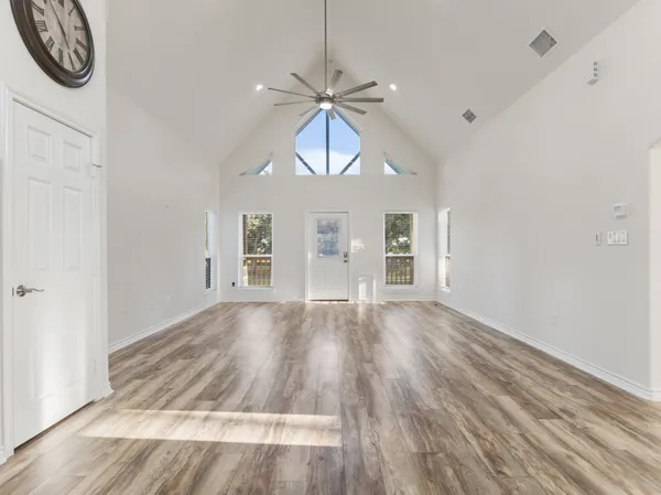 a view of empty room with wooden floor
