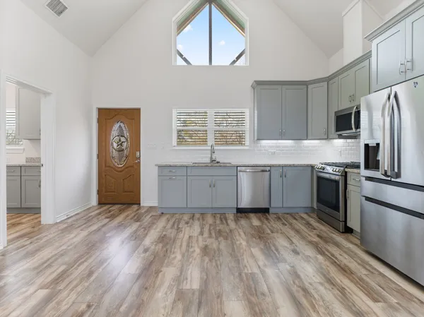 a kitchen with stainless steel appliances granite countertop a stove a sink and a refrigerator