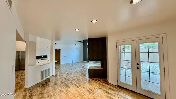 a view of a kitchen with refrigerator and wooden floor