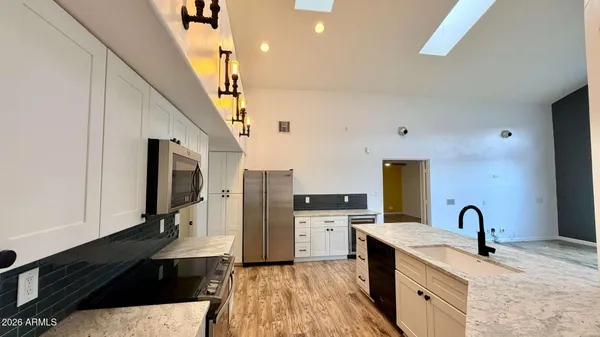 a kitchen with stainless steel appliances granite countertop a sink stove and refrigerator