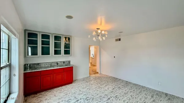 a view of kitchen with granite countertop cabinets and chandelier