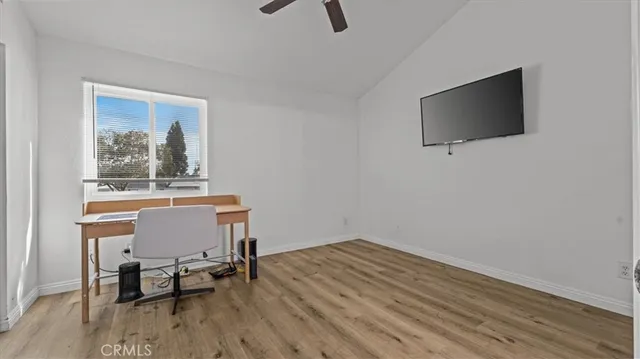 a workspace with wooden floor and a flat screen tv