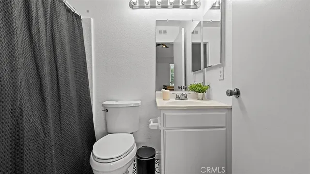 a bathroom with a toilet a sink and mirror
