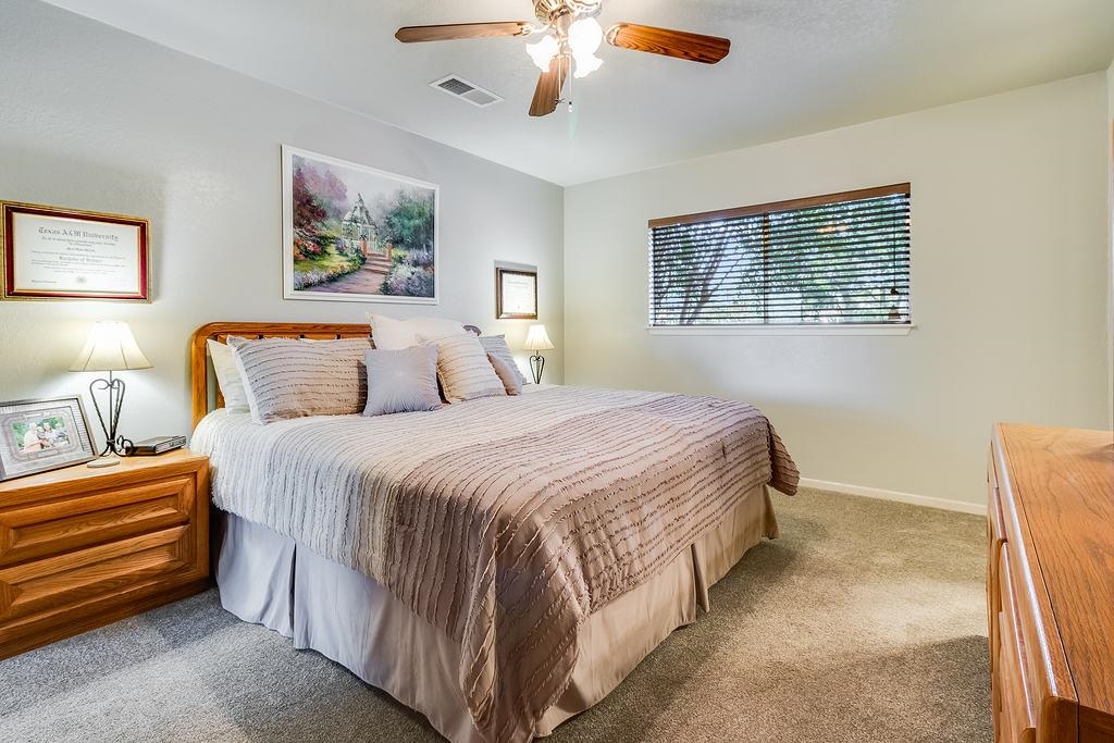 104 Rio Vista Road Burnet, TX 78611 - Photo 12 of 30 a bedroom with a bed and a chandelier