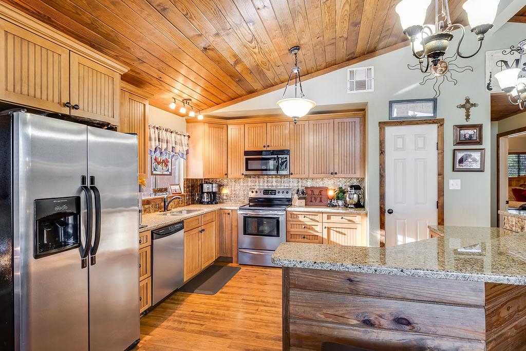 104 Rio Vista Road Burnet, TX 78611 - Photo 16 of 30 a kitchen with stainless steel appliances granite countertop a refrigerator a stove and a sink