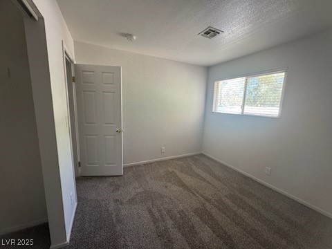 4360 Twin View Circle, Unit 4 Las Vegas, NV 89121 - Photo 14 of 17 Empty room with dark colored carpet and a textured ceiling