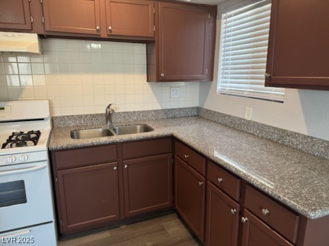 4360 Twin View Circle, Unit 4 Las Vegas, NV 89121 - Photo 4 of 17 Kitchen featuring white gas range, under cabinet range hood, dark wood-style floors, and backsplash
