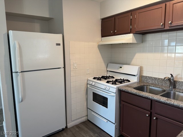 4360 Twin View Circle, Unit 4 Las Vegas, NV 89121 - Photo 5 of 17 Kitchen with white appliances, under cabinet range hood, dark wood-style floors, tile walls, and tasteful backsplash