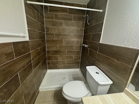 4360 Twin View Circle, Unit 4 Las Vegas, NV 89121 - Photo 9 of 17 Bathroom with tile walls, a shower stall, a textured wall, a wainscoted wall, and vanity