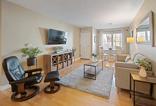 a living room with furniture a flat screen tv and a large window