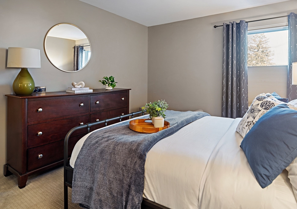 30 Franklin Street, Unit 124 Malden, MA 02148 - Photo 13 of 23 a bedroom with a bed and a mirror