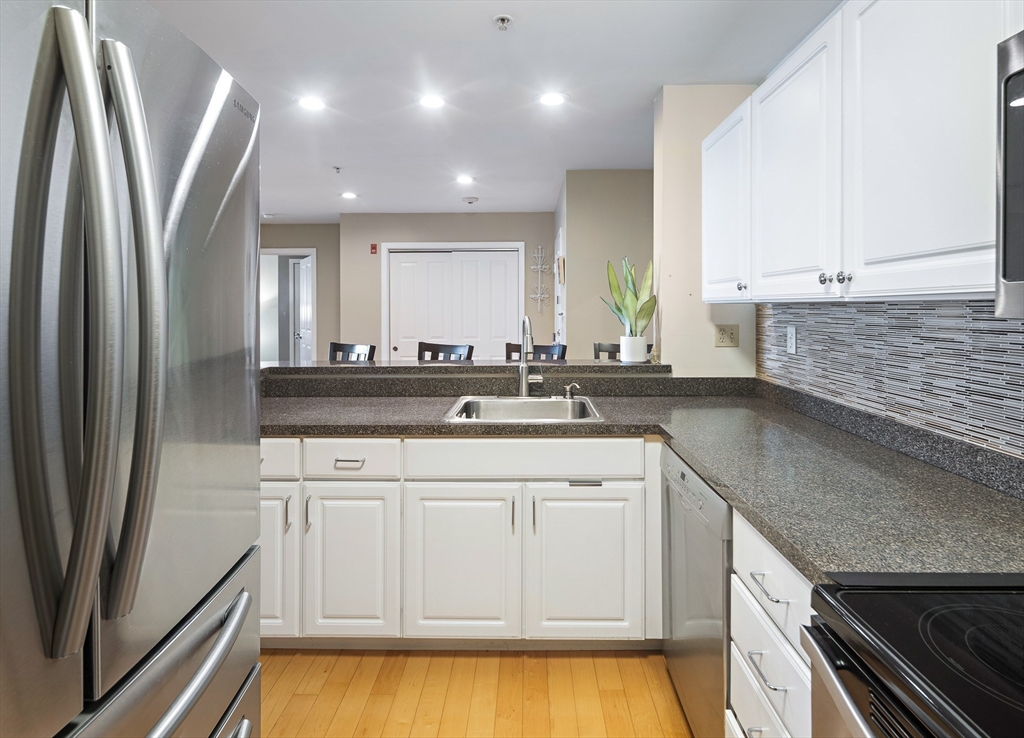 30 Franklin Street, Unit 124 Malden, MA 02148 - Photo 7 of 23 a kitchen with stainless steel appliances granite countertop a sink and a refrigerator