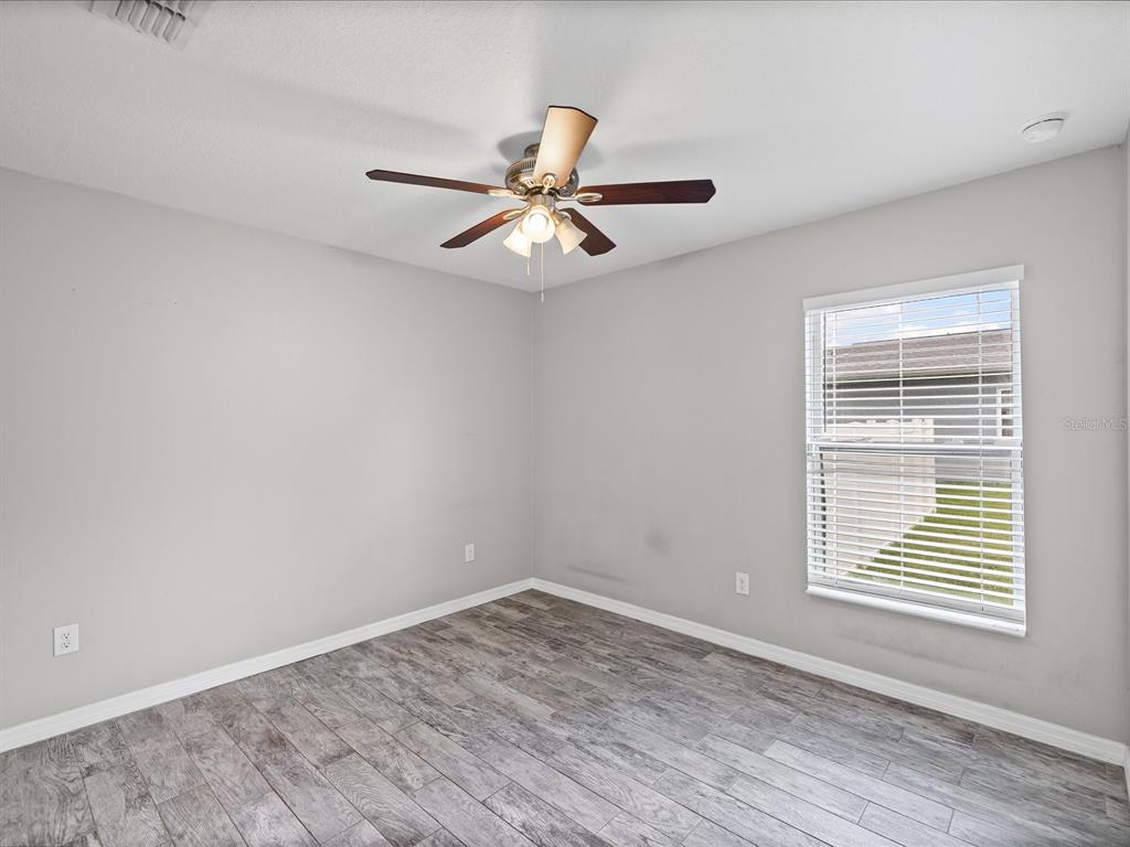 1238 Vista Way Clearwater, FL 33755 - Photo 11 of 32 wooden floor in an empty room with a window