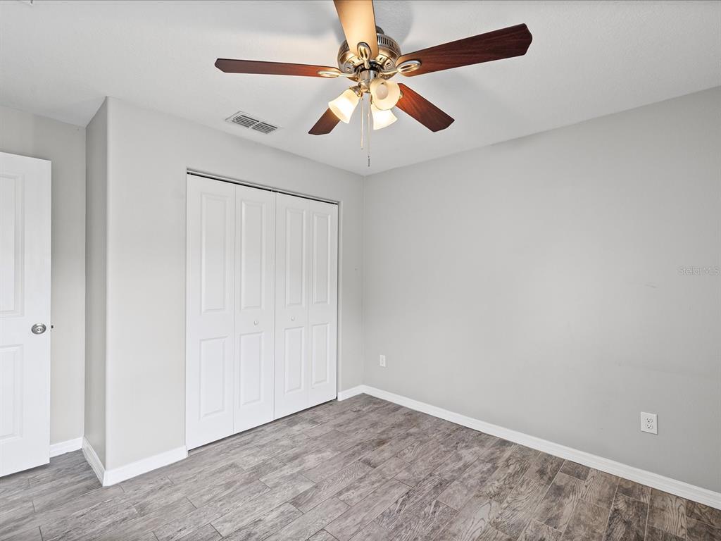 1238 Vista Way Clearwater, FL 33755 - Photo 12 of 32 wooden floor in an empty room with a chandelier fan
