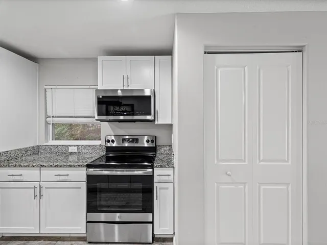a kitchen with white cabinets and stainless steel appliances