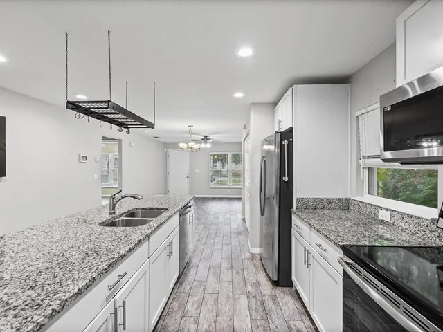 a kitchen with granite countertop a stove and a wooden floor