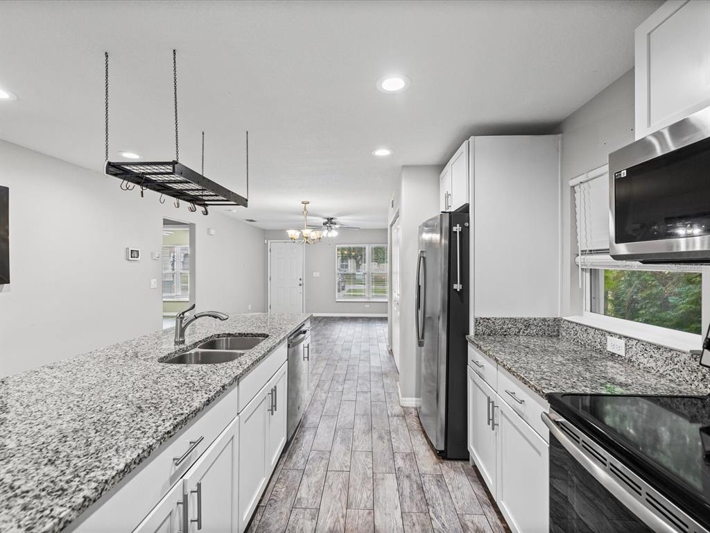1238 Vista Way Clearwater, FL 33755 - Photo 17 of 32 a kitchen with granite countertop a stove and a wooden floor