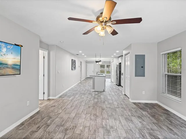a view of a livingroom with wooden floor and a ceiling fan