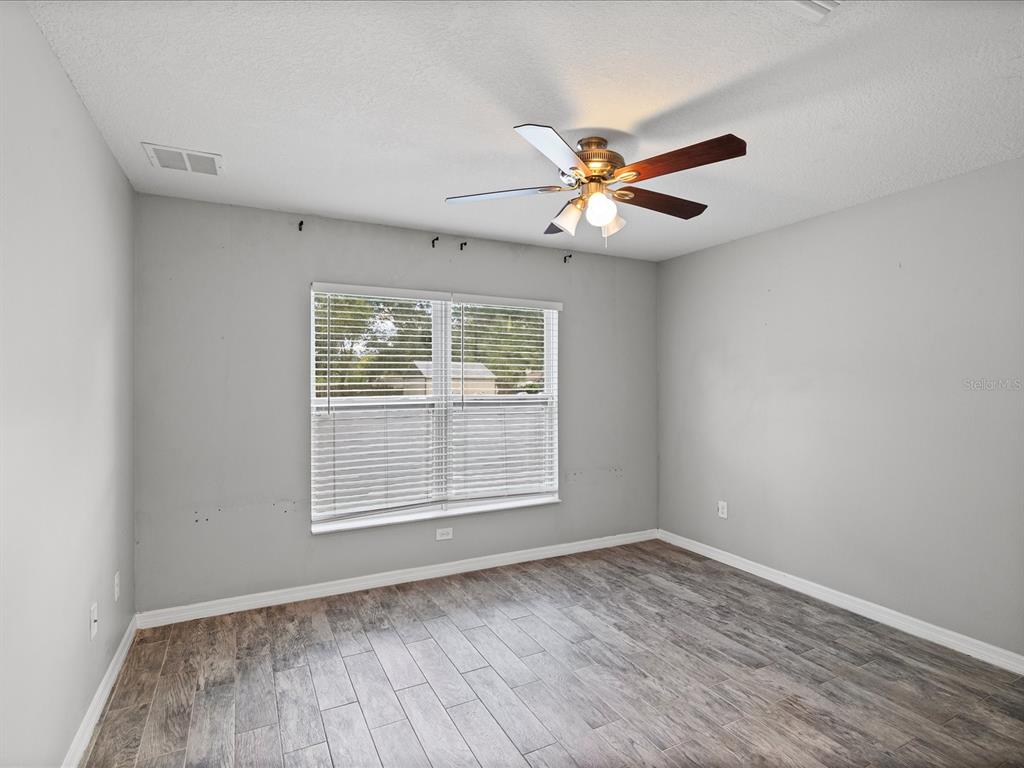 1238 Vista Way Clearwater, FL 33755 - Photo 21 of 32 an empty room with wooden floor fan and windows