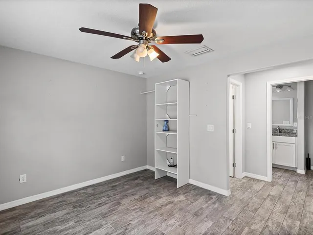 a view of empty room with wooden floor