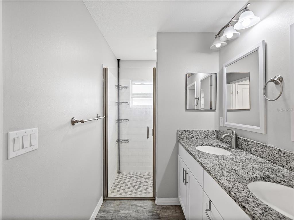 1238 Vista Way Clearwater, FL 33755 - Photo 25 of 32 a bathroom with a granite countertop sink mirror and shower
