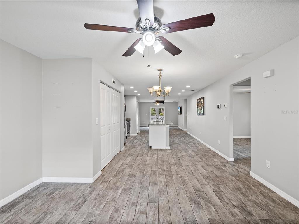 1238 Vista Way Clearwater, FL 33755 - Photo 3 of 32 wooden floor in an empty room with a chandelier fan