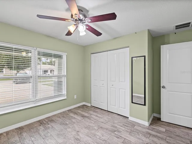 a view of an empty room with a window and a kitchen