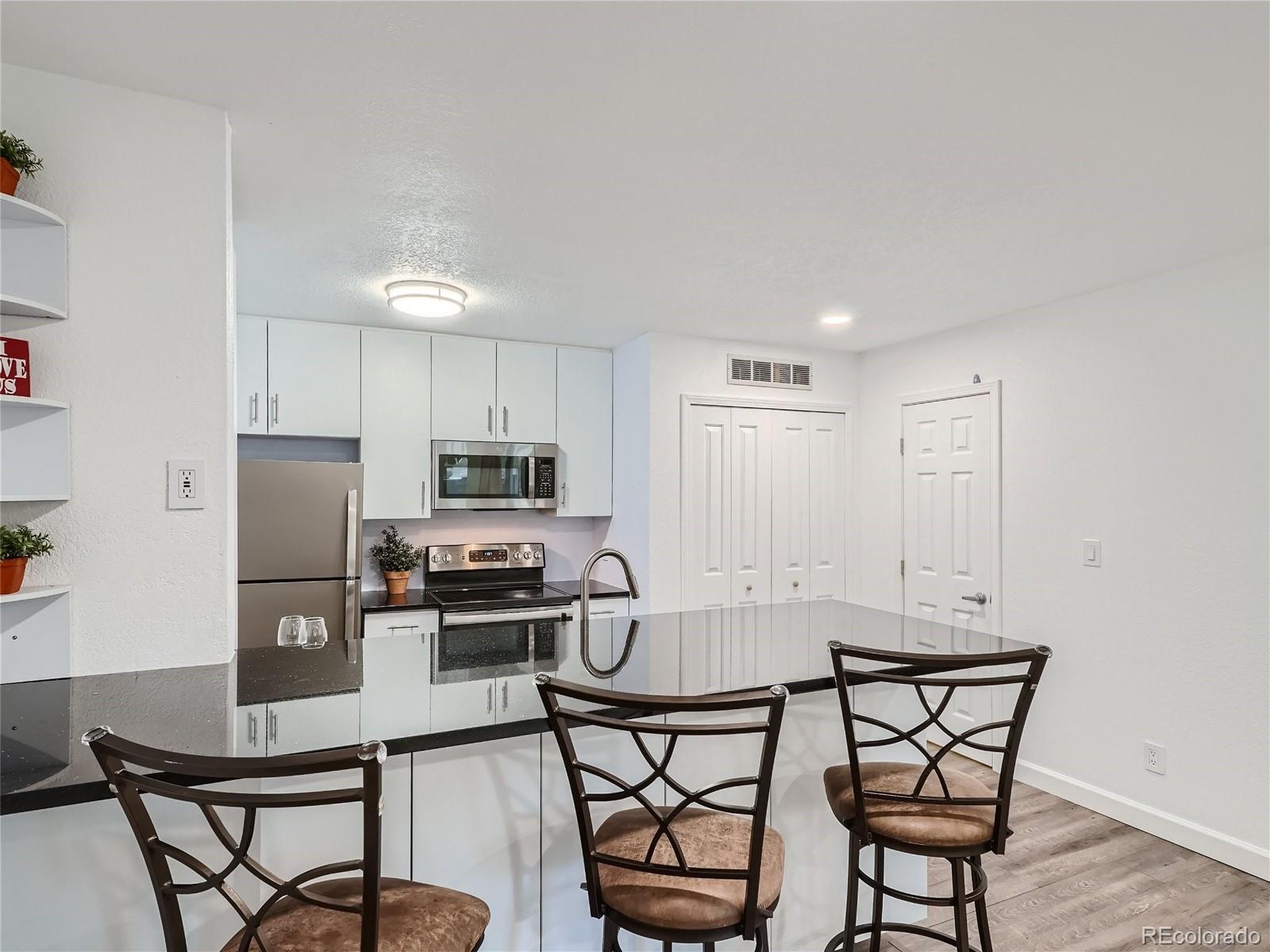 a kitchen with stainless steel appliances wooden cabinets dining table and chairs