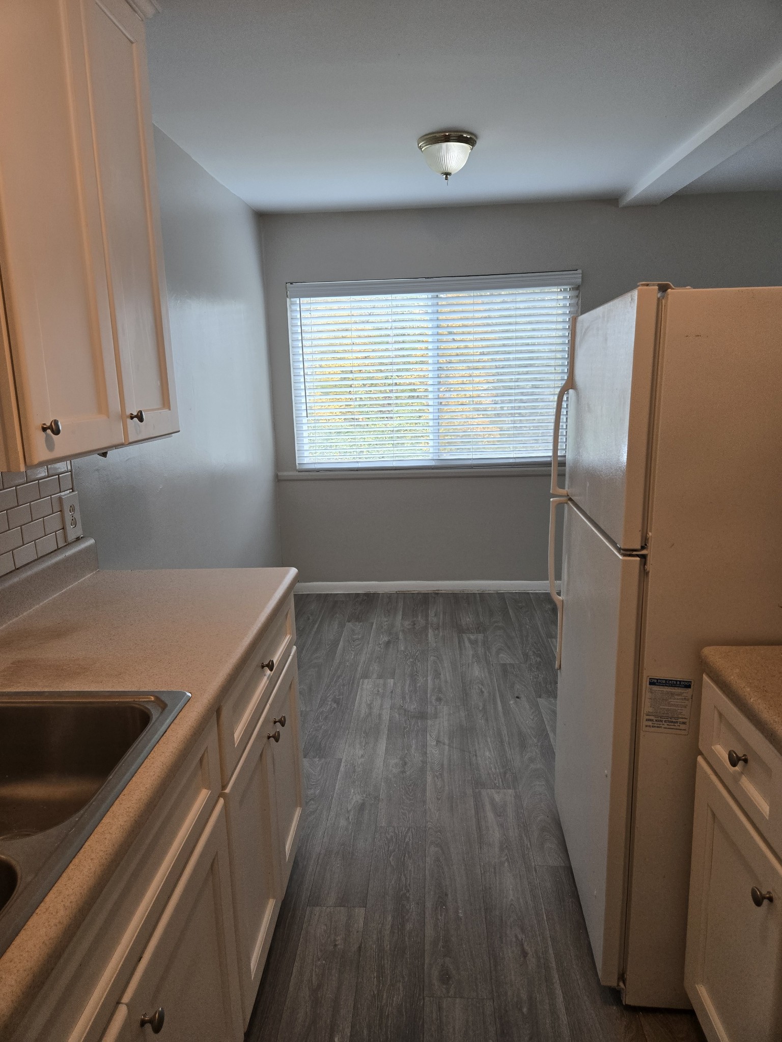 550 Harding Place, Unit E113 Nashville, TN 37211 - Photo 2 of 13 a room with a refrigerator a sink and wooden floor