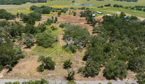 an aerial view of residential houses with outdoor space and trees