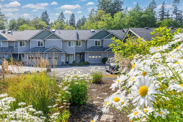 a front view of a house with a yard and fountain