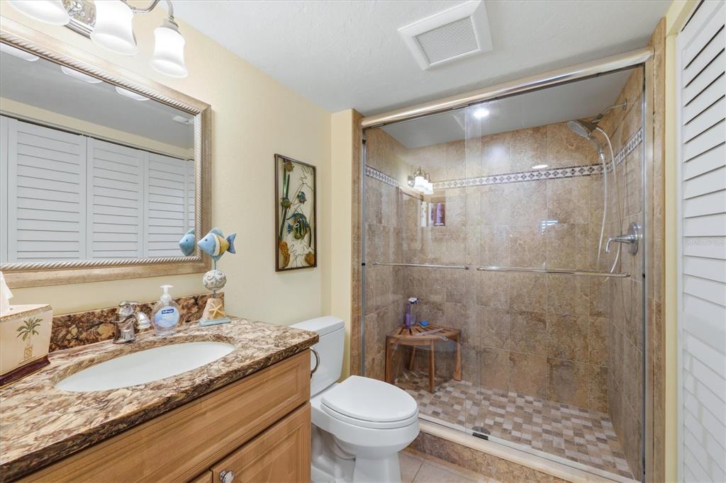 2729 North Beach Road, Unit 211 Englewood, FL 34223 - Photo 33 of 51 a bathroom with a granite countertop sink toilet and shower