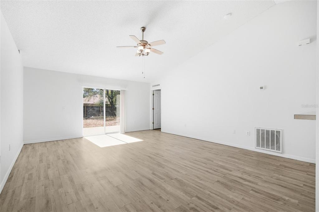80 Providence Lane Palm Coast, FL 32164 - Photo 13 of 42 a view of an empty room with a window and wooden floor