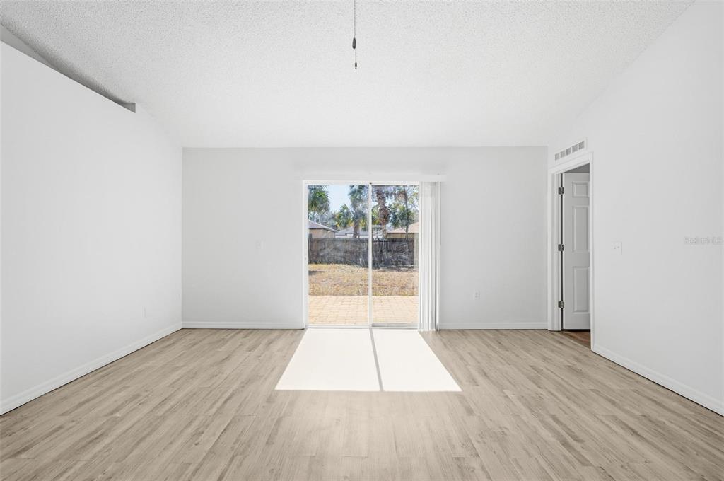 80 Providence Lane Palm Coast, FL 32164 - Photo 17 of 42 an empty room with wooden floor and windows