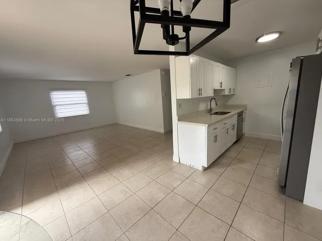 a kitchen with stainless steel appliances granite countertop a stove a refrigerator and a cabinets