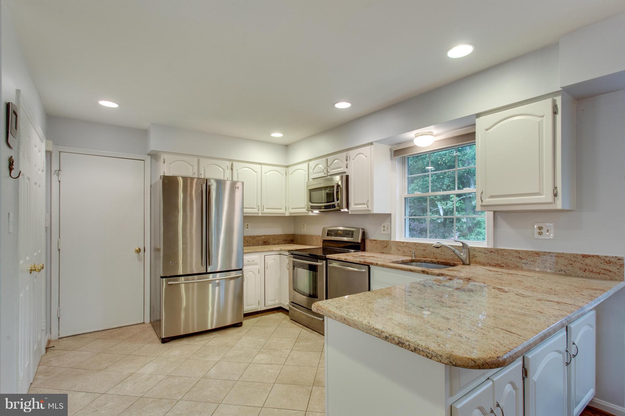 8230 Stacey Road Alexandria, VA 22308 - Photo 3 of 30 a kitchen with stainless steel appliances granite countertop a refrigerator and a sink