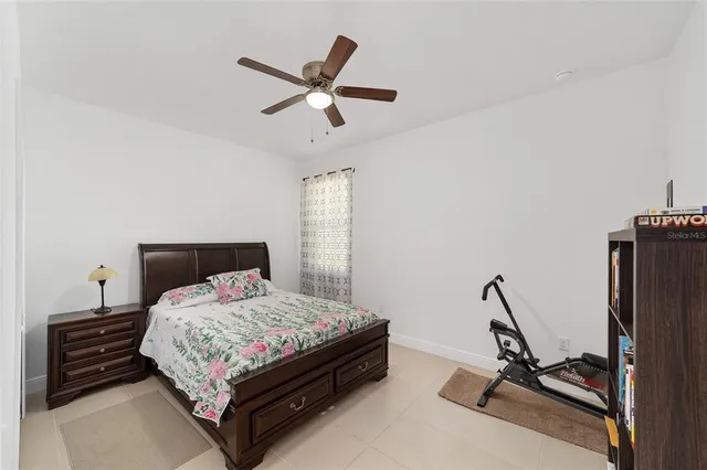 a bedroom with a bed and a ceiling fan