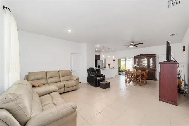 a living room with furniture and a dining table with kitchen view