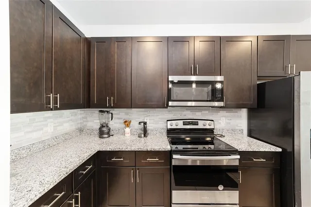 a kitchen with a sink a microwave a refrigerator and cabinets