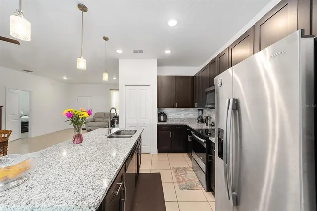 a kitchen with stainless steel appliances granite countertop a sink refrigerator and microwave
