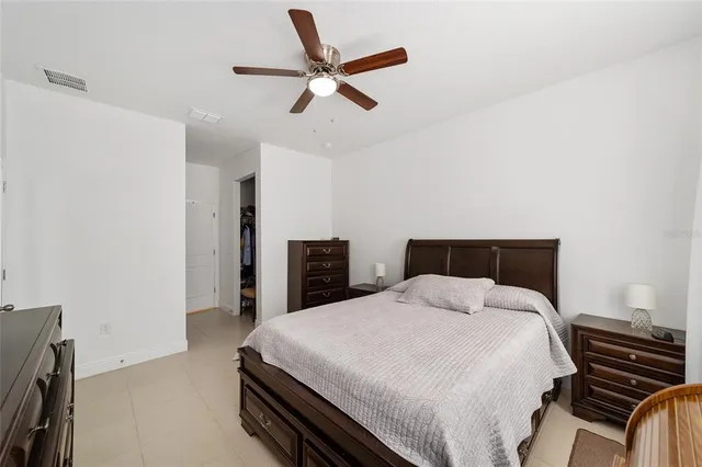 a bedroom with a bed and a ceiling fan