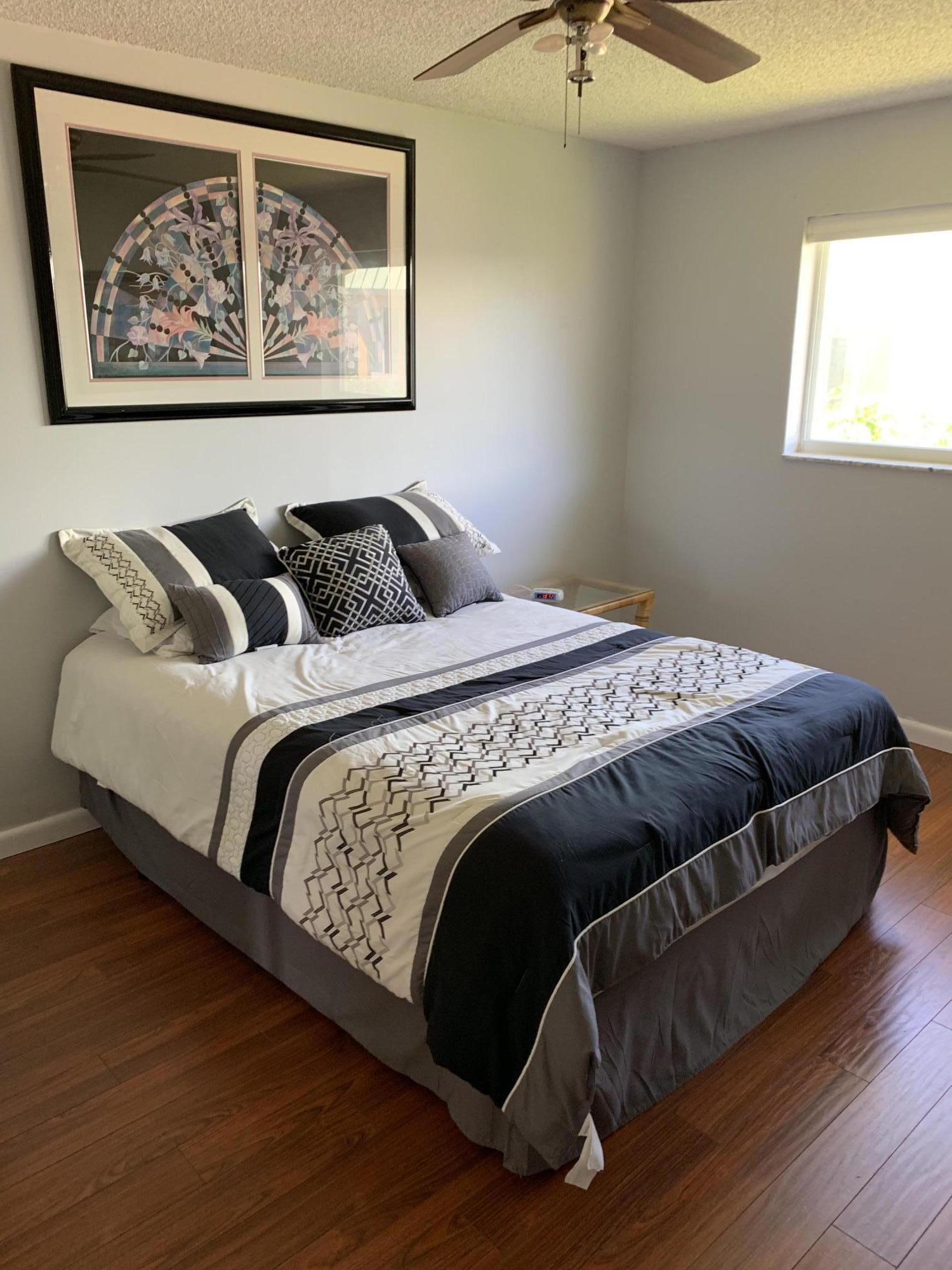 19 Colonial Club Drive, Unit 202 Boynton Beach, FL 33435 - Photo 11 of 18 a bed sitting in a bedroom next to a window