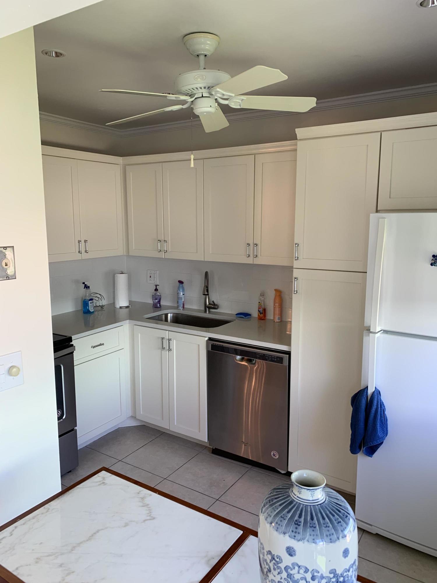19 Colonial Club Drive, Unit 202 Boynton Beach, FL 33435 - Photo 9 of 18 a kitchen with a sink a refrigerator and cabinets