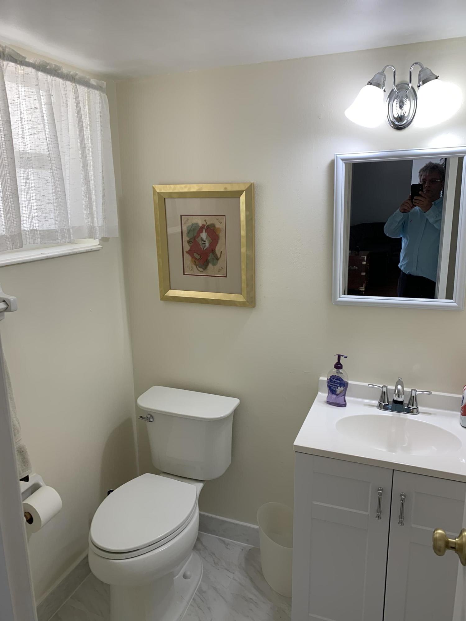 19 Colonial Club Drive, Unit 202 Boynton Beach, FL 33435 - Photo 10 of 18 a bathroom with a toilet a sink and mirror