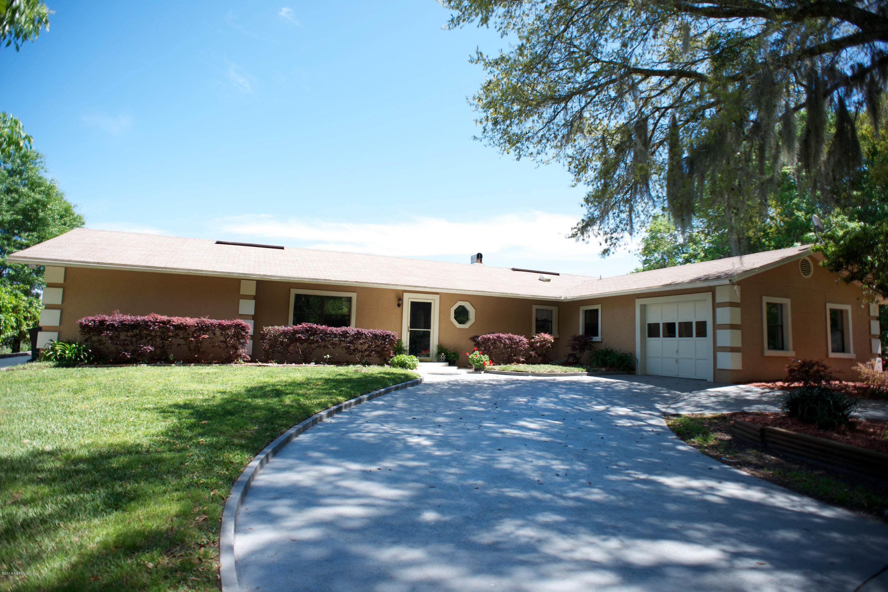 4109 Magnolia Road Orange Park, FL 32065 - Photo 2 of 32 a front view of a house with a garden and trees