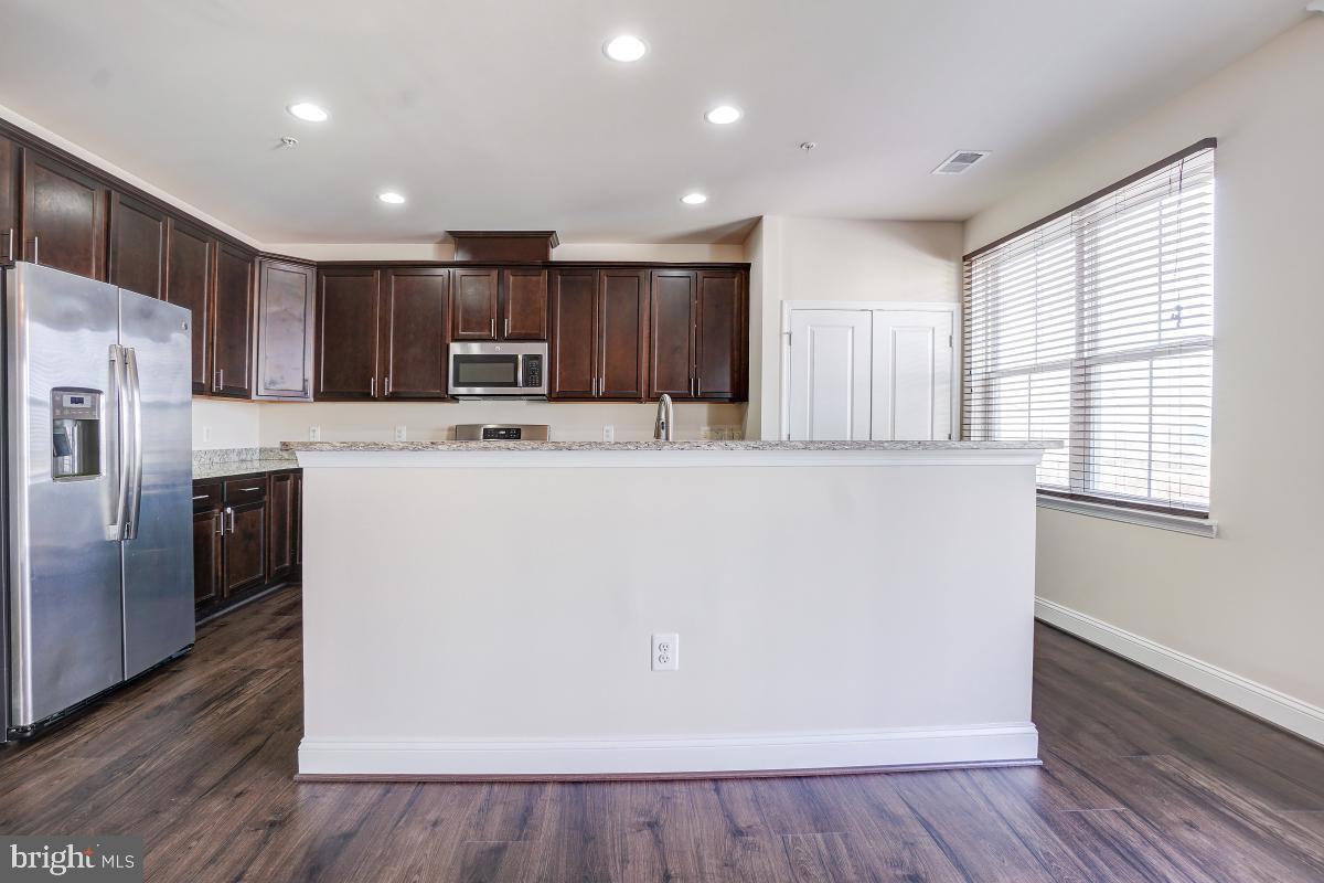 1709 Fieldstone Court Hanover, MD 21076 - Photo 11 of 30 a white kitchen with wooden floor and a refrigerator