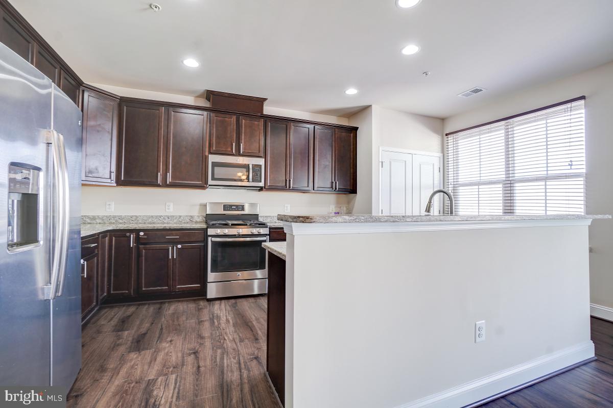 1709 Fieldstone Court Hanover, MD 21076 - Photo 12 of 30 a kitchen with stainless steel appliances granite countertop a stove a sink and a refrigerator