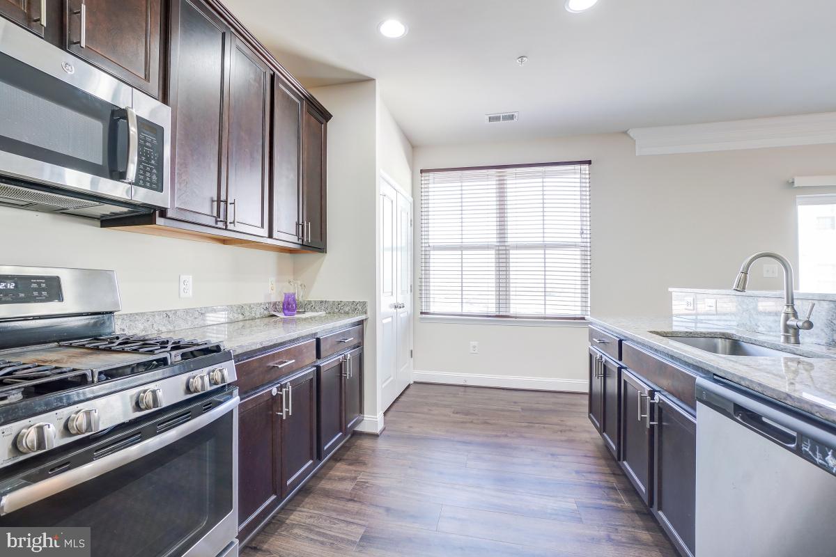1709 Fieldstone Court Hanover, MD 21076 - Photo 13 of 30 a kitchen with stainless steel appliances granite countertop a stove a sink and a refrigerator